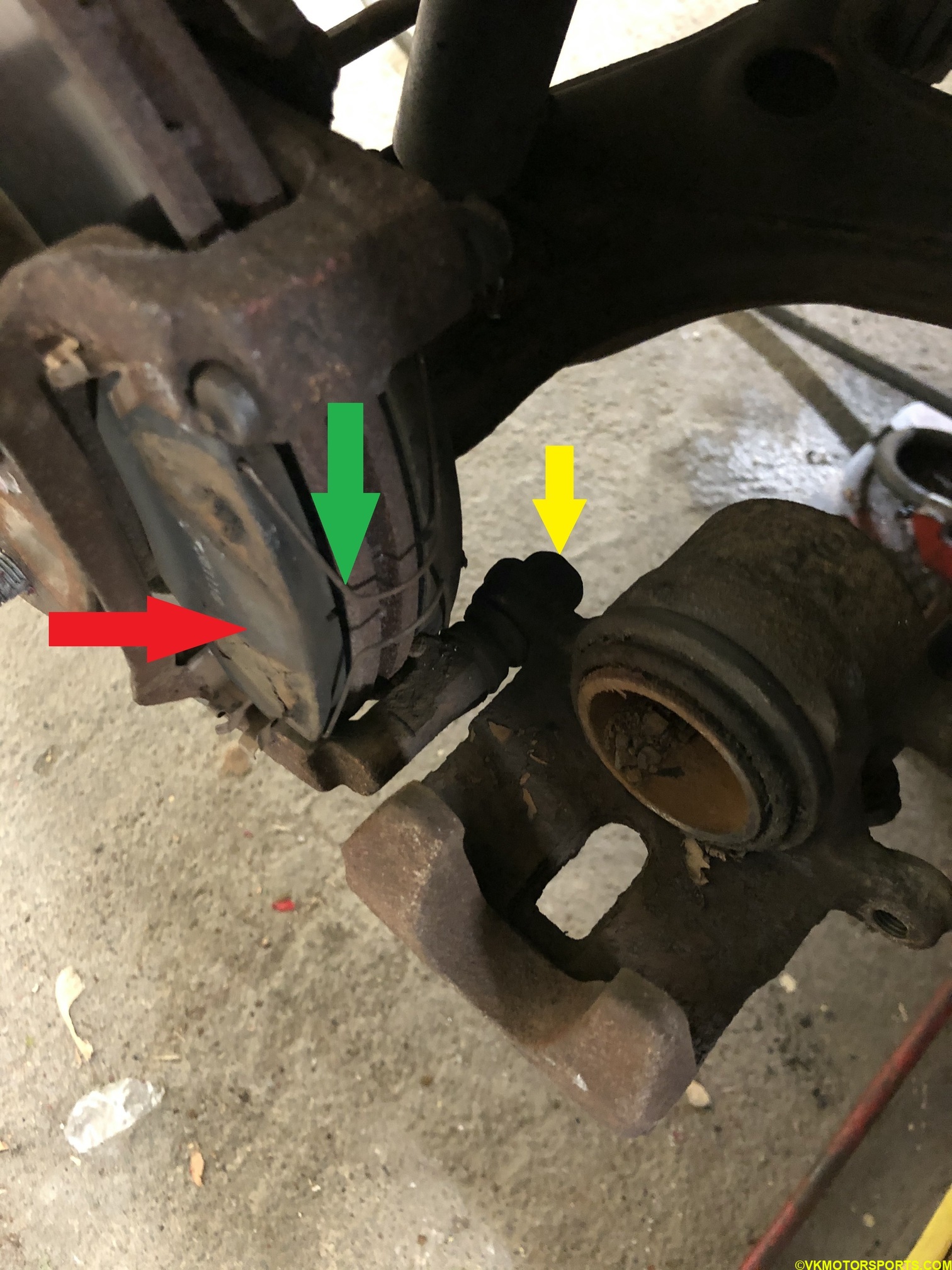 Figure 7. Flipped caliper showing the old pads and holding clip