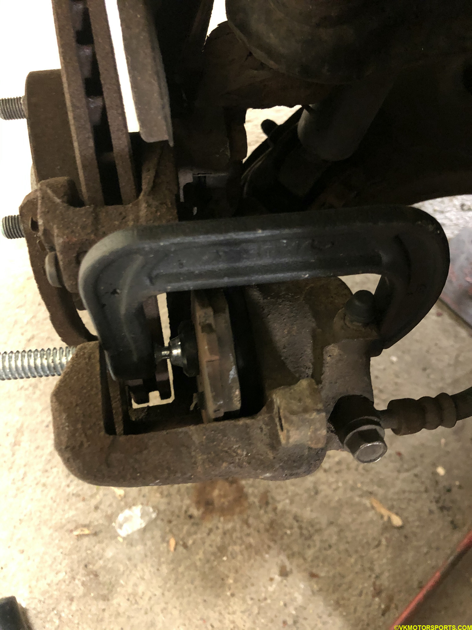 Figure 14. C-clamp and old brake pad against piston
