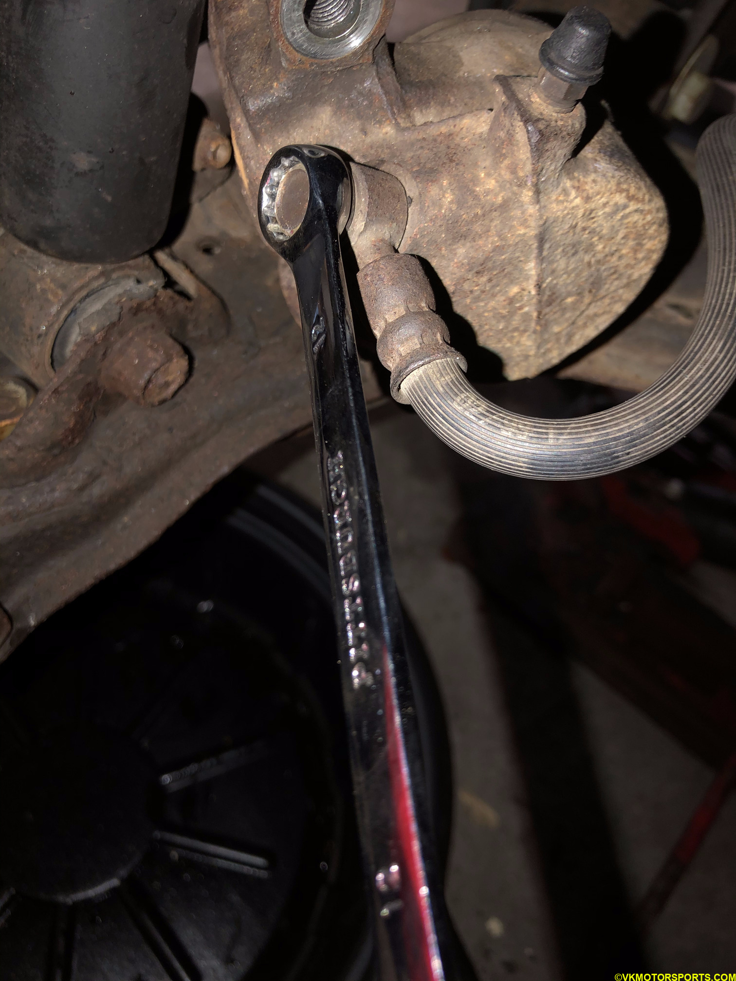 Loosen the brake line bolt using a 12mm socket/wrench
